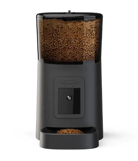 Black pet food dispenser with brown kibble on a white background
